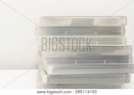 Dvd Cases Stacked On Surface. On White Surface, Infront Of White Background.