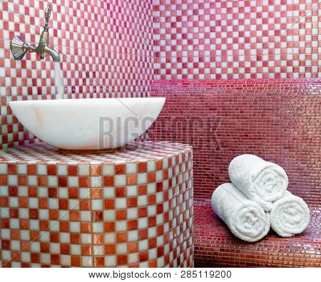 Traditional Turkish Hamam With Stone Walls, Sink And Stack Of  Towels
