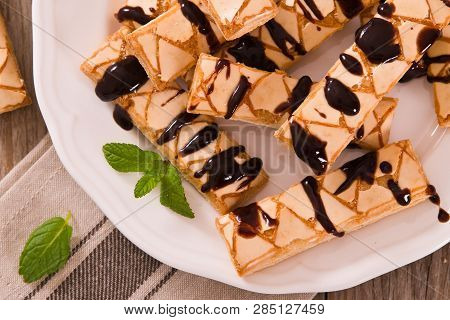 Puff Pastry Cookies With Chocolate Icing On White Dish.