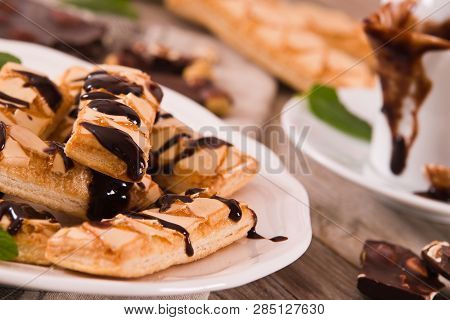 Puff Pastry Cookies With Chocolate Icing On White Dish.