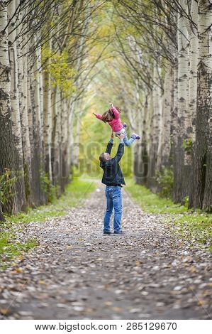 Happy Father Toss Up Little Child. Family Playing In City Park. Healthy Lifestyle, Outdoor Activity.
