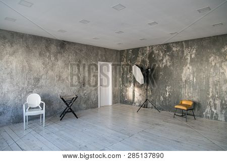 Modern Light Loft-style Room With Designer Chairs And Lighting. Gray Walls With The Texture Of The C