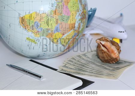 Planning A Trip Around The World. On Holiday With The Whole Family. In The Photo: Plane, Money, Shel