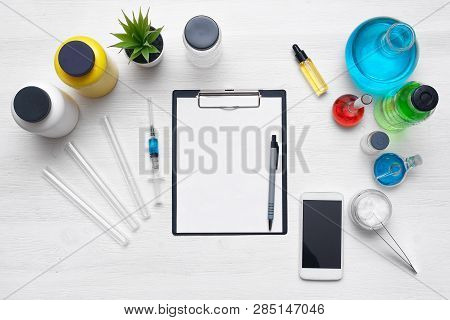 Laboratory Table With A Blank Paper Sheet Of Researching Results, Mobile Phone And A Chemical Reagen