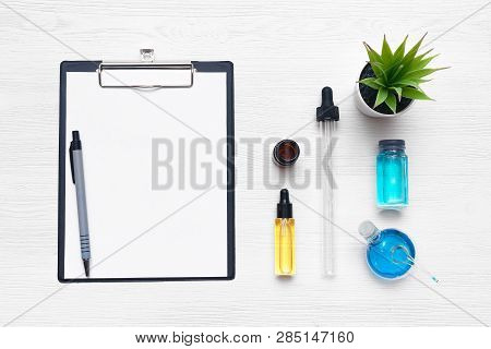 Laboratory Table With A Blank Paper Sheet Of Researching Results Or Medical Recipe And A Chemical Re
