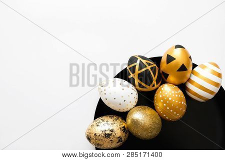 Stylish Easter Golden Decorated Eggs On Black Plate Isolated On White Background. Trendy Flat Lay Ea