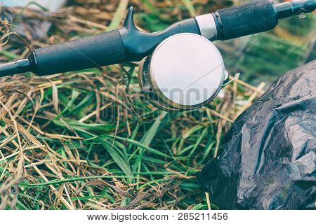 Spinning Rod With Baitcasting Reel On The Grass. Selective Focus