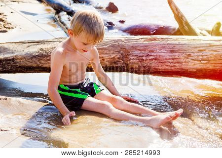 Child Playing In The Sand On The Summer Beach