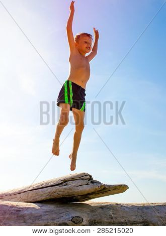Happy Child Jumping On The Summer Beach