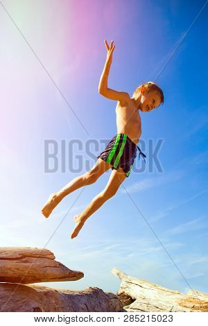 Happy Child Jumping On The Summer Beach