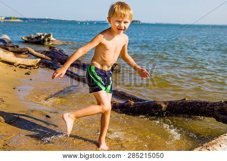 Happy Child Running On The Summer Beach