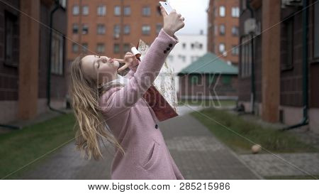 Young Happy Blonde Girl After Shopping Doing Selfie With Bright Packages