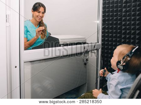 Smiling Audiologist Doing Hearing Test To Little Boy