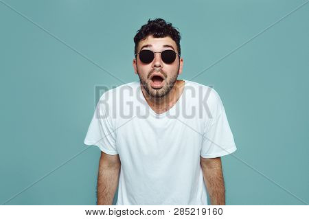 Indoor Shot Of Stupefied Handsome Male Opens Mouth Widely, Wears White T Shirt, Has Shocked Expressi