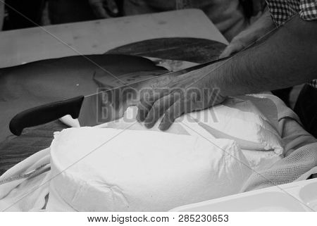 Cheesemaker Slicing A Fresh Cheese With Special Knife