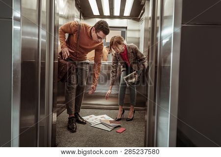 Helpful Boyfriend Assisting His Woman After Dropping Papers