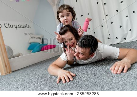Smiling happy family and young funny daughter. Family concept.  On background Bible verses philippia