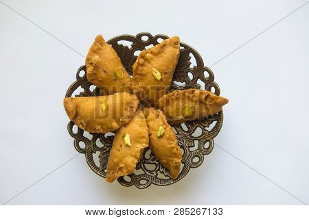Authentic North Indian sweet -Gujia, arranged on a traditional decorative tray. Holi festival special sweets and treat.
