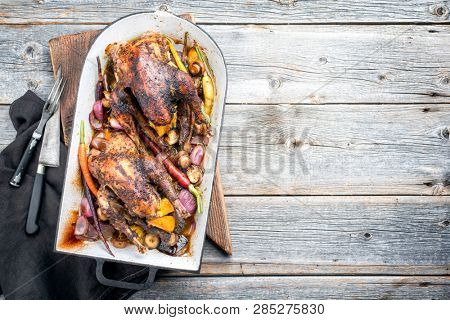Traditional barbecue pheasant with vegetable and game sauce as top view in a stewpot with copy space right