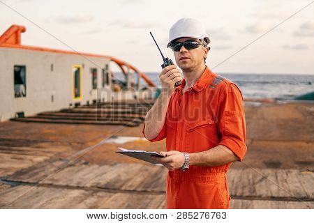 Deck Officer On Deck Of Offshore Vessel Holds Vhf Walkie-talkie Radio