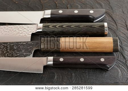 Knife handles on black cutting board, close-up