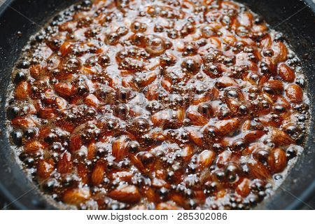 roasted almonds with cinnamon sugar cooking process, close-up view