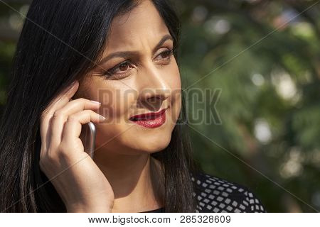 Face Of Petty Indian Woman Frowning When Making Phone Call