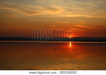 Sunt Setting Over The Mountains With Refletions Over The Water