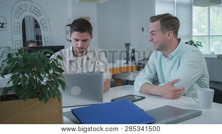 Young Happy Man Laughs. Men Have Fun At The Working Place In The Office. Beginner Writer Working On 