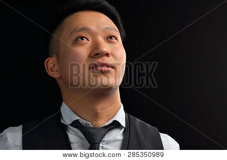 Portrait Of An Asian Young Man Looking Up, Dressed In A Shirt, Smiling