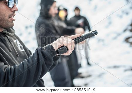 Close-up Detail View Of Shooter Hold Handgun In Row Group Of People On The Shooting Range