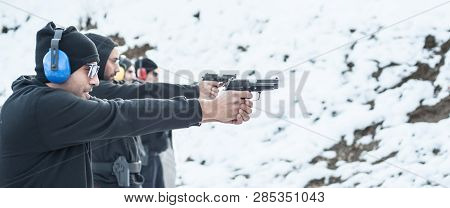 Close-up Detail View Of Shooter Hold Handgun In Row Group Of People On The Shooting Range