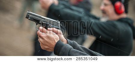 Close-up Detail View Of Shooter Hold Handgun In Row Group Of People On The Shooting Range