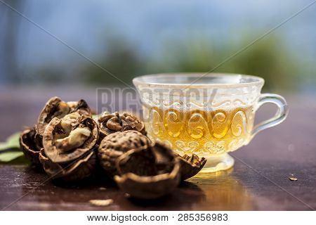 Close Up Of Herbal Organic Tea Of Wall Nut Or Walnut Tea In A Transparent Glass Cup With Raw Wall Nu