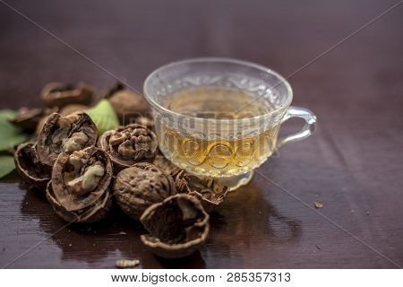 Close Up Of Herbal Organic Tea Of Wall Nut Or Walnut Tea In A Transparent Glass Cup With Raw Wall Nu
