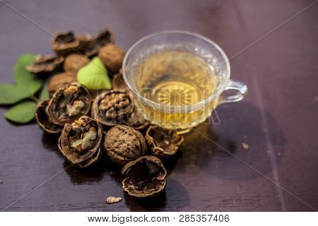 Close Up Of Herbal Organic Tea Of Wall Nut Or Walnut Tea In A Transparent Glass Cup With Raw Wall Nu