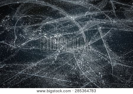 Surface of outdoor ice with snow, replete with skate marks. Abstract Ice background