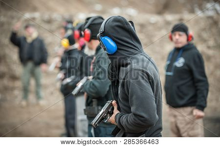 Close-up Detail View Of Shooter Hold Handgun In Row Group Of People On The Shooting Range