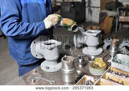 The Base For The Valve Is Mounted On An Iron Table For Assembly At The Factory And The Worker Instal