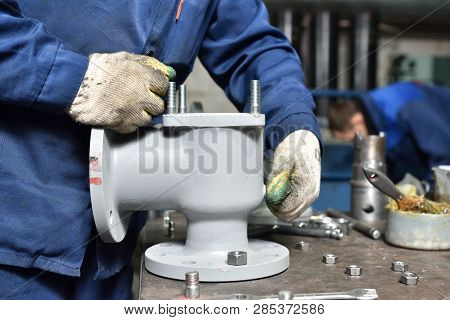 The Base For The Valve Is Mounted On An Iron Table For Assembly At The Factory And The Worker Instal