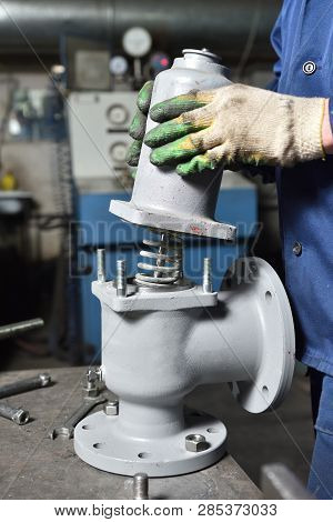 The Base For The Valve Is Mounted On An Iron Table For Assembly At The Factory And The Worker Instal