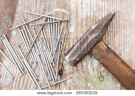 Vintage Joiner Hammer And Nails (hobnails) Lying On Old Wooden Table Or Workbench With Splashes Pain