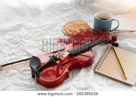 The Classic Violin And Bow Put Beside Coffee Cup Book,blurry Liight Around