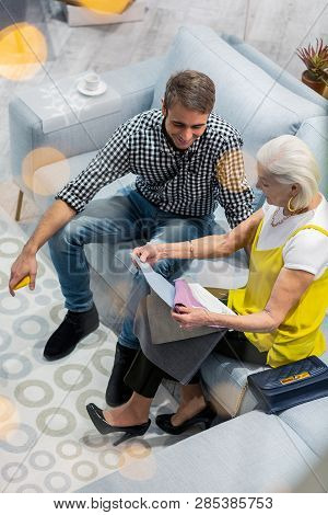 Nice-appealing Mature Man Selecting Sofa Textile With Aged Fashionable Mother