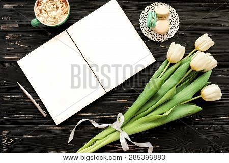 Beautiful Bouquet Of White Tulips, Empty Open Notebook, Silver Pen, Cup Of Cappuccino, Makaroons On 