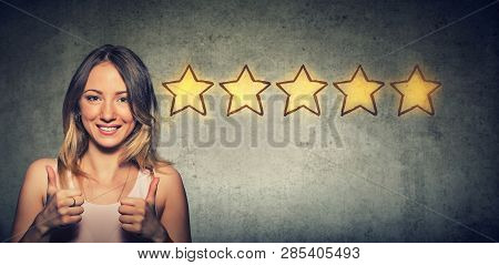 Сheerful Beautiful Woman Smiling Showing Thumb Up Like Gesture Choosing Five Stars Rating. Excellent
