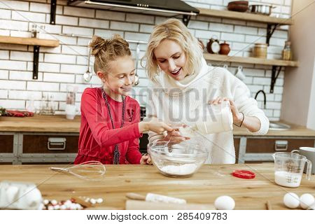 Contented Smiling Woman Pouring Flour From Clear Bottle