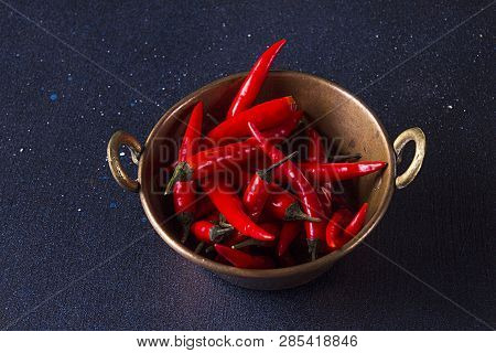 Red Spisy Small Chili Peppers In Cooper Bowl On Dark Background.