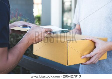 Delivery Mail Man Giving Parcel Box To Recipient And Signature Form, Young Owner Signing Receipt Of