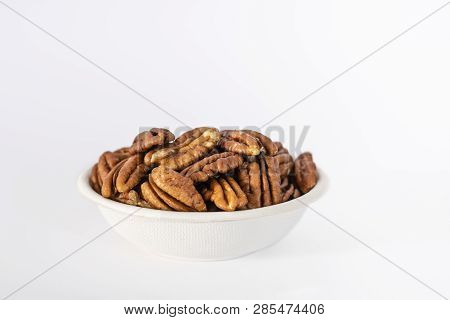 Bowl Of Pecan Nuts (carya Illinoinensis) On A White Background